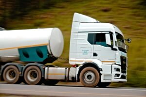 Home Close-up of a fast-moving white tanker truck on a highway, capturing motion and speed.