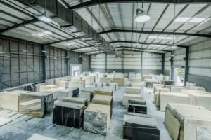 Home Expansive warehouse filled with large stone slabs for industrial use.